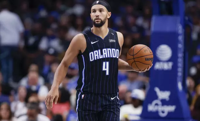 Orlando Magic guard Jalen Suggs brings the ball downcourt during the second half of an NBA basketball game against the Dallas Mavericks, Sunday, Nov. 3, 2024, in Dallas. (AP Photo/Gareth Patterson)