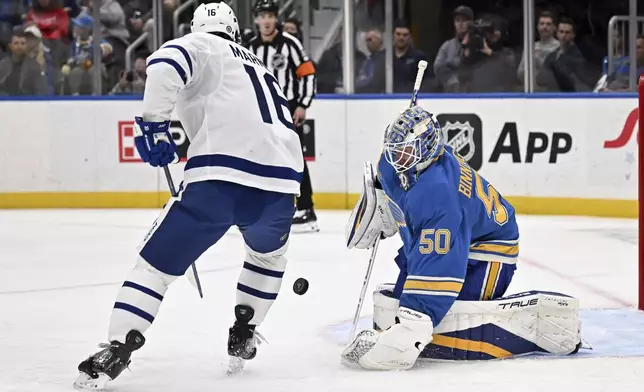 St. Louis Blues' goaltender Jordan Binnington (50) defends the net against Toronto Maple Leafs' Mitch Marner (15), left, during the first period of an NHL hockey game Saturday, Nov. 2, 2024, in St. Louis. (AP Photo/Connor Hamilton)