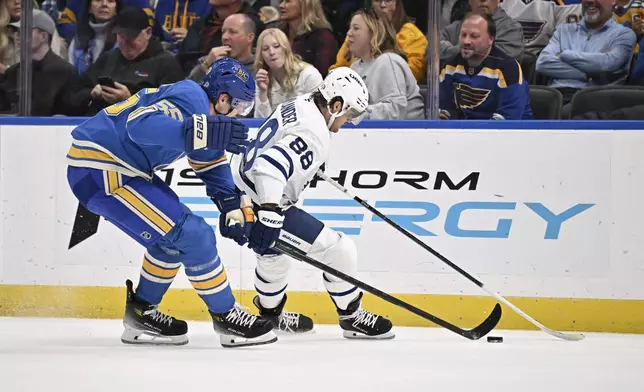 St. Louis Blues' Colton Parayko (55), left, and Toronto Maple Leafs' William Nylander (88), right, battle for a loose puck during the first period of an NHL hockey game Saturday, Nov. 2, 2024, in St. Louis. (AP Photo/Connor Hamilton)