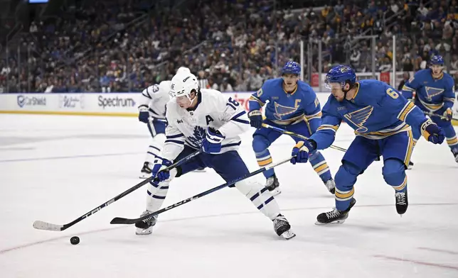 Toronto Maple Leafs' Mitch Marner (15) controls the puck as St. Louis Blues' Philip Broberg (6) defends during the first period of an NHL hockey game Saturday, Nov. 2, 2024, in St. Louis. (AP Photo/Connor Hamilton)