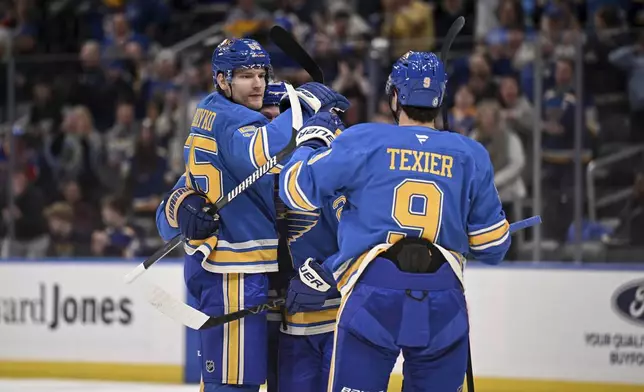 St. Louis Blues' Colton Parayko, left, celebrates with teammates after scoring during the second period of an NHL hockey game against the Toronto Maple Leafs, Saturday, Nov. 2, 2024, in St. Louis. (AP Photo/Connor Hamilton)