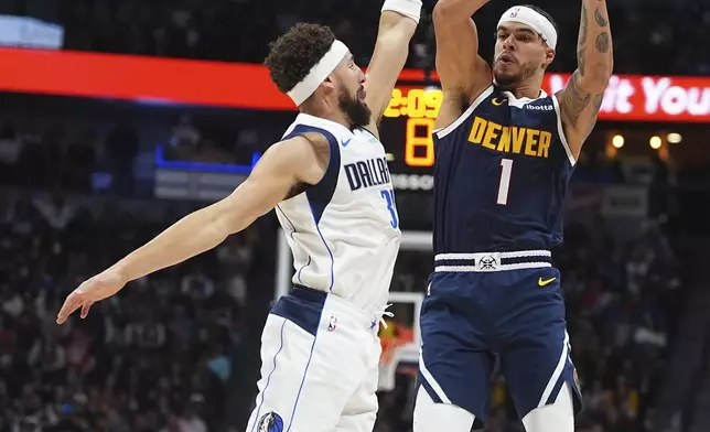 Denver Nuggets forward Michael Porter Jr., right, shoots over Dallas Mavericks guard Klay Thompson in the second half of an NBA basketball game, Sunday, Nov. 10, 2024, in Denver. (AP Photo/David Zalubowski)