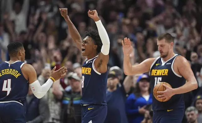 Denver Nuggets forward Peyton Watson, center, celebrates with guard Russell Westbrook (4) and center Nikola Jokic after Dallas Mavericks guard Kyrie Irving missed a last-second shot as time ran out in the second half of an NBA basketball game Sunday, Nov. 10, 2024, in Denver. (AP Photo/David Zalubowski)