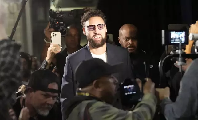 Dallas Mavericks guard Klay Thompson is greeted by Golden State Warriors employees and media as he arrives before an Emirates NBA Cup basketball game between the Warriors and the Mavericks in San Francisco, Tuesday, Nov. 12, 2024. (AP Photo/Jeff Chiu)