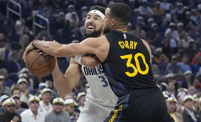 Dallas Mavericks guard Klay Thompson, left, loses the ball while driving to the basket against Golden State Warriors guard Stephen Curry (30) during the first half of an Emirates NBA Cup basketball game in San Francisco, Tuesday, Nov. 12, 2024. (AP Photo/Jeff Chiu)