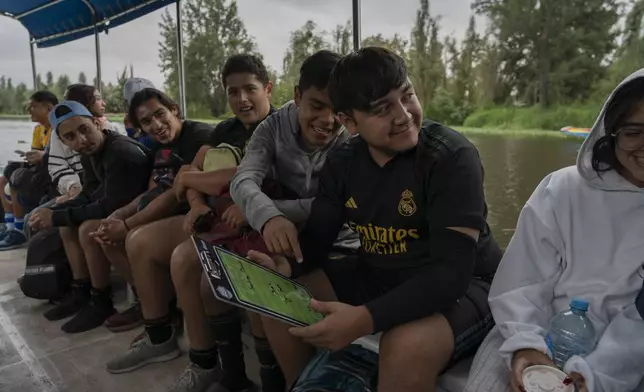 Amateur soccer players from the Tumbados team travel in a traditional canoe in the Xochimilco borough of Mexico City, on Sunday, October 20, 2024. (AP Photo/Felix Marquez)