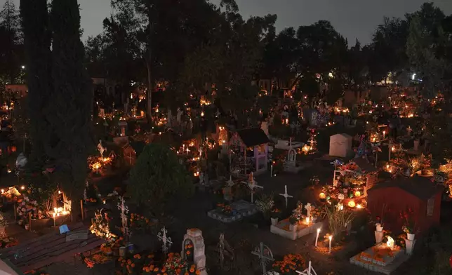 Families gather to keep company with their dearly departed, celebrating Day of the Dead at the San Gregorio Atlapulco cemetery, on the outskirts of Mexico City, Saturday, Nov. 2, 2024. (AP Photo/Moises Castillo)