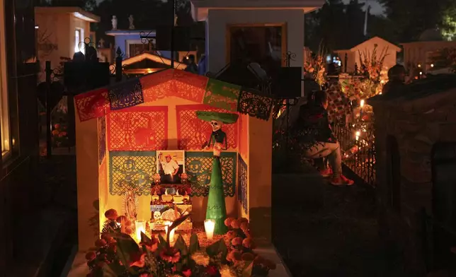 A tomb is decorated with a Catrina sculpture and cempasúchil flowers or marigolds, celebrating Day of the Dead, at the San Gregorio Atlapulco cemetery on the outskirts of Mexico City, Friday, Nov. 1, 2024. (AP Photo/Moises Castillo)