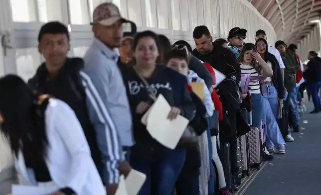 Migrants wait in line for U.S. agents to examine their documents requesting an appointment to apply for asylum, at the Paso del Norte international bridge, in Ciudad Juarez, Mexico, Friday, Nov. 1, 2024. (AP Photo/Christian Chavez)