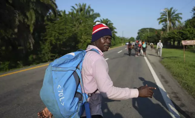 An African migrant looks over his shoulder while walking alongside the highway in Escuintla, southern Mexico, heading toward the country's northern border and ultimately the United States, Thursday, Nov. 7, 2024. (AP Photo/Moises Castillo)