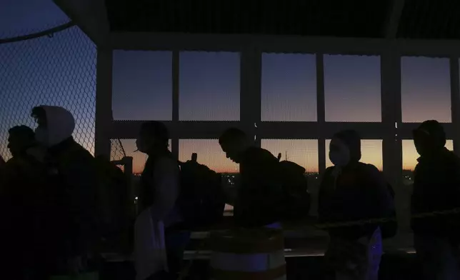 Migrants line up to present to U.S. agents documents requesting appointment to apply for asylum at the Paso del Norte international bridge, in Ciudad Juarez, Mexico, Tuesday Nov 5, 2024. (AP Photo/Christian Chavez)