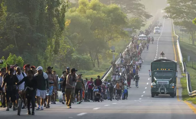 Migrants walk along the highway in Huixtla, southern Mexico, heading toward the country's northern border and ultimately the United States, Thursday, Nov. 7, 2024. (AP Photo/Moises Castillo)