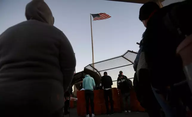 Migrants line up to present to U.S. agents documents requesting an appointment to apply for asylum at the Paso del Norte international bridge, in Ciudad Juarez, Mexico, Tuesday, Nov 5, 2024. (AP Photo/Christian Chavez)