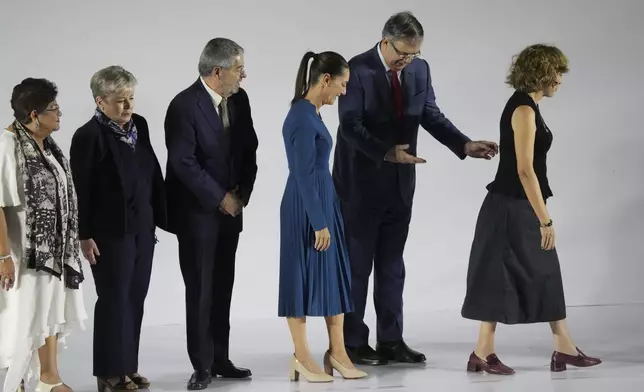 FILE - Newly-named Economy Minister Marcelo Ebrard makes a “you go first” gesture to incoming President Claudia Sheinbaum, as they exit a press conference where Sheinbaum presented six members of her Cabinet, in Mexico City, June 20, 2024. (AP Photo/Marco Ugarte, File)