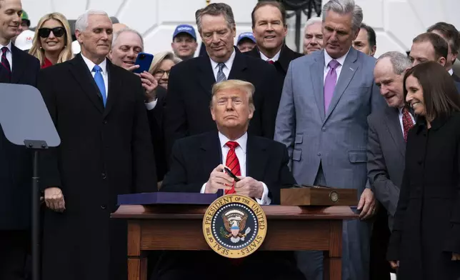 FILE - President Donald Trump signs a new North American trade agreement with Canada and Mexico, at the White House in Washington, Jan. 29, 2020. (AP Photo/ Evan Vucci, File)