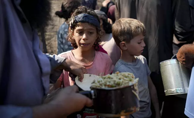 FILE - Palestinians line up for food distribution in Deir al-Balah, Gaza Strip, Thursday, Oct. 17, 2024. (AP Photo/Abdel Kareem Hana, File)