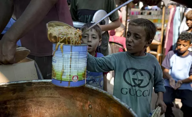 FILE - A displaced child lines up for food distribution in Deir al-Balah, Gaza Strip, on Oct. 17, 2024. (AP Photo/Abdel Kareem Hana, File)