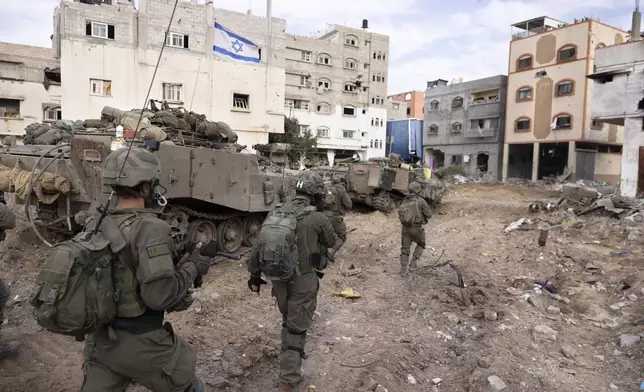 FILE - Israeli soldiers walk in Gaza City's Shijaiyah neighborhood on Dec. 8, 2023, as part of an operation to round up hundreds of Palestinians across the northern Gaza Strip and truck some to an undisclosed location. (AP Photo/Moti Milrod, Haaretz, File)