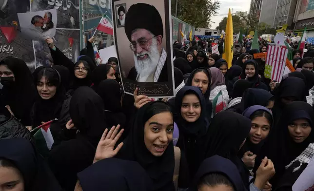 Holding a poster of the Iranian Supreme Leader Ayatollah Ali Khamenei, students attend an annual rally in front of the former U.S. Embassy in Tehran, Iran, Sunday, Nov. 3, 2024, marking the 45th anniversary of Iranian students' takeover of the embassy, starting a hostage crisis. (AP Photo/Vahid Salemi)