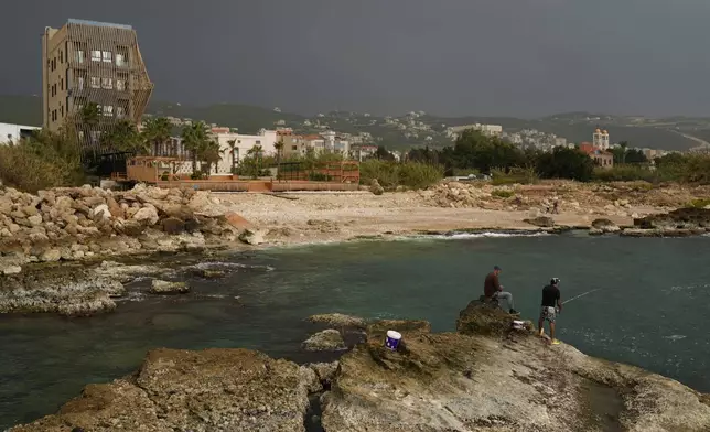 Lebanese fishermen cast their fishing rods at a beach in Batroun, northern Lebanon, Saturday, Nov. 2, 2024, where Lebanese officials say a ship captain was taken away by a group of armed men who landed on a coast north of Beirut and they're investigating whether Israel was involved. (AP Photo/Hussein Malla)