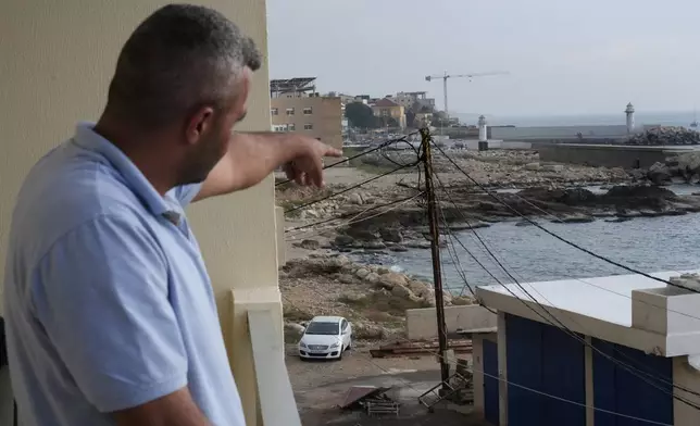 A Lebanese man points to the beach in Batroun, northern Lebanon, Saturday, Nov. 2, 2024, where Lebanese officials say a group of armed men landed on a coast north of Beirut and took away a ship captain and they're investigating whether Israel was involved. (AP Photo/Hussein Malla)