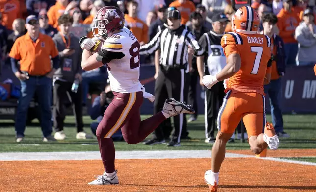 Minnesota tight end Jameson Geers catches a touchdown pass past Illinois defensive back Matthew Bailey, from quarterback Max Brosmer during the second half of an NCAA college football game Saturday, Nov. 2, 2024, in Champaign, Ill. (AP Photo/Charles Rex Arbogast)