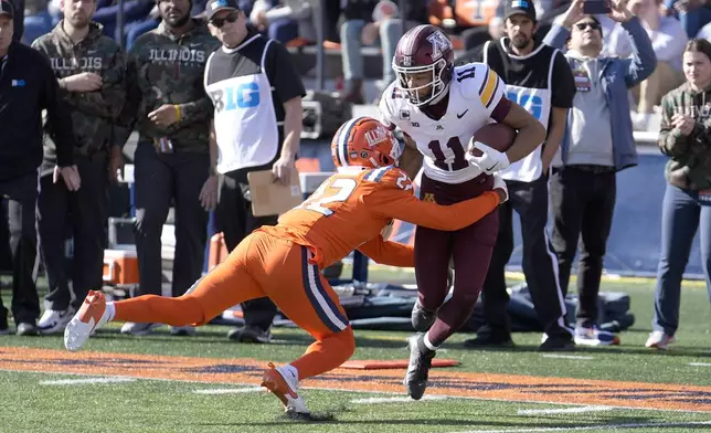 Minnesota wide receiver Elijah Spencer advances the ball off a pass reception as Illinois defensive back Kaleb Patterson makes the tackle during the first half of an NCAA college football game Saturday, Nov. 2, 2024, in Champaign, Ill. (AP Photo/Charles Rex Arbogast)