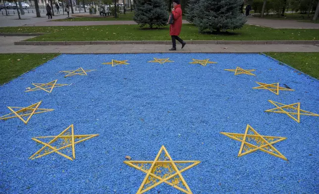 FILE - A woman walks by a depiction of the European Union flag near a park in central Chisinau, Moldova, Oct. 17, 2024. (AP Photo/Vadim Ghirda, File)