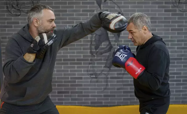 Moldovan historian and politician Octavian Ticu, right, trains with coach Igor Rotaru, in a gym in Chisinau, Moldova, Oct. 18, 2024. (AP Photo/Vadim Ghirda)