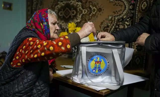 A woman casts her vote in a mobile ballot box during a presidential election runoff, in the village of Ciopleni, Moldova, Sunday, Nov. 3, 2024. (AP Photo/Vadim Ghirda)