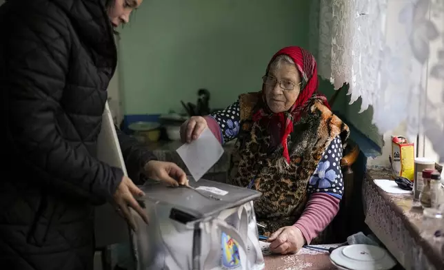 A woman casts her vote in a mobile ballot box during a presidential election runoff, in the village of Ciopleni, Moldova, Sunday, Nov. 3, 2024. (AP Photo/Vadim Ghirda)