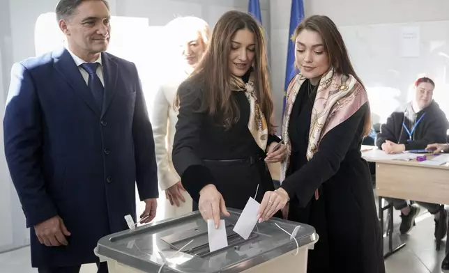 Alexandr Stoianoglo, from left, presidential candidate of the Socialists' Party of Moldova (PSRM), watches his daughters Cristina and Corina cast their votes during a presidential election runoff, in Chisinau, Moldova, Sunday, Nov. 3, 2024. (AP Photo/Vadim Ghirda)