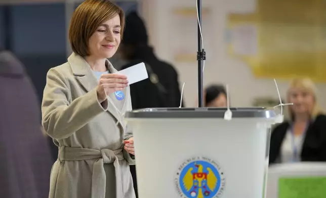 Moldova's President Maia Sandu prepares to cast her vote during a presidential election runoff, in Chisinau, Moldova, Sunday, Nov. 3, 2024. (AP Photo/Vadim Ghirda)