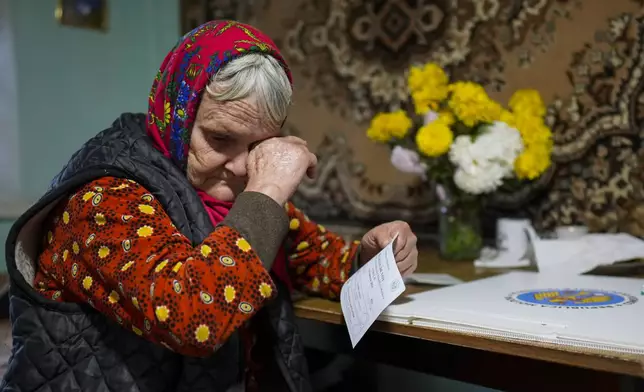 A woman wipes her eyes before casting her vote in a mobile ballot box during a presidential election runoff, in the village of Ciopleni, Moldova, Sunday, Nov. 3, 2024. (AP Photo/Vadim Ghirda)