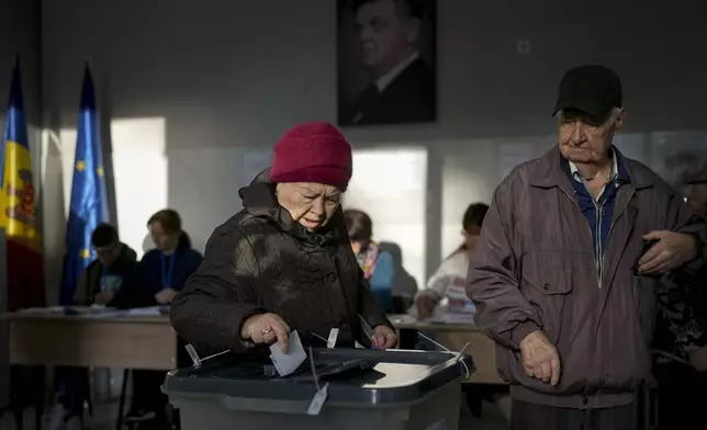 A woman prepares to cast her vote during a presidential election runoff, in Chisinau, Moldova, Sunday, Nov. 3, 2024. (AP Photo/Vadim Ghirda)