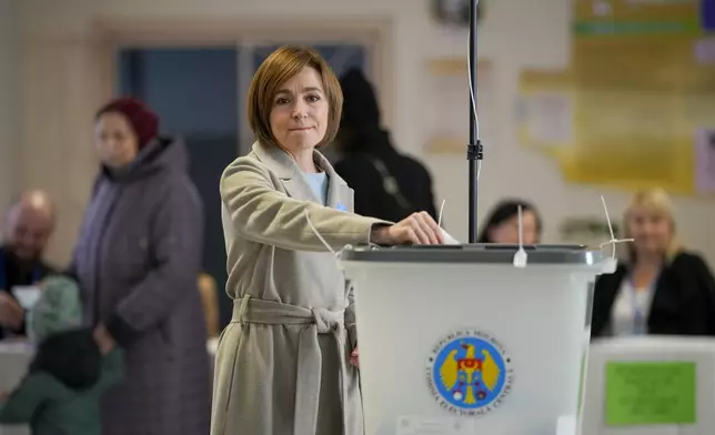 Moldova's President Maia Sandu prepares to cast her vote during a presidential election runoff, in Chisinau, Moldova, Sunday, Nov. 3, 2024. (AP Photo/Vadim Ghirda)