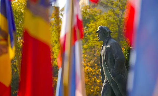 A view of the statue of Lenin next to Moldovan and Gagauz flags, in Comrat, the capital of Gagauzia, an autonomous part of Moldova, Saturday, Nov. 2, 2024, ahead of a presidential election runoff taking place on Sunday. (AP Photo/Vadim Ghirda)