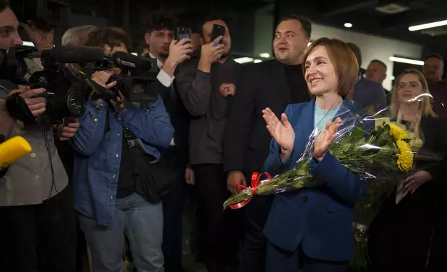 Moldova's President Maia Sandu celebrates with supporters as preliminary results are announced for the presidential election runoff in Chisinau, Moldova, late Sunday, Nov. 3, 2024. (AP Photo/Vadim Ghirda)