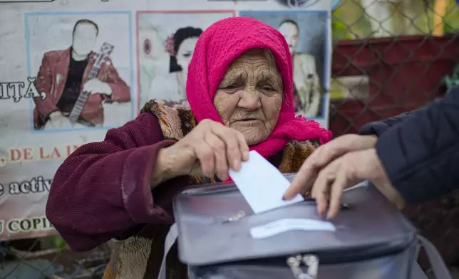 A woman casts her vote in a mobile ballot box during a presidential election runoff, in the village of Ciopleni, Moldova, Sunday, Nov. 3, 2024. (AP Photo/Vadim Ghirda)