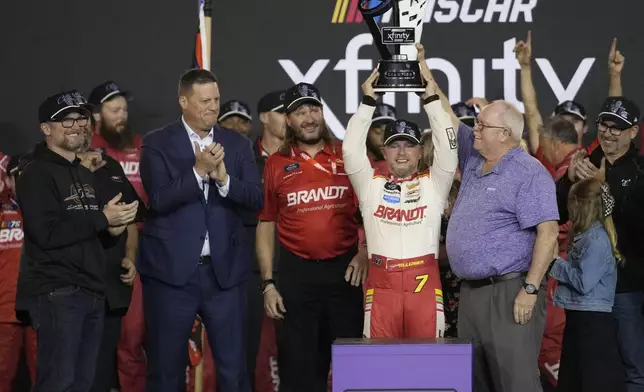 Justin Allgaier holds up the trophy as Team owner Dale Earnhardt Jr., left, cheers after winning the championship after a NASCAR Xfinity Series auto race, Saturday, Nov. 9, 2024, in Avondale, Ariz. (AP Photo/John Locher)