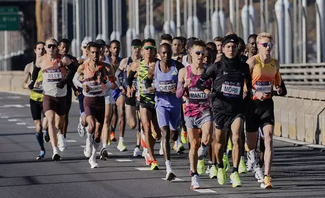 Yuma Morii, right center, of Japan, makes his way onto the Verrazzano Narrows bridge with runners in the men's elite division make their way from the start line during the New York City Marathon, Sunday, Nov. 3, 2024, in New York. (AP Photo/Eduardo Munoz Alvarez)