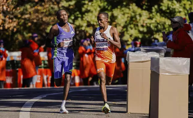 Abdi Nageeye, of the Netherlands, right, runs to crosses the finish line to win the men's division of the New York City Marathon, Sunday, Nov. 3, 2024, in New York. (AP Photo/Eduardo Munoz Alvarez)