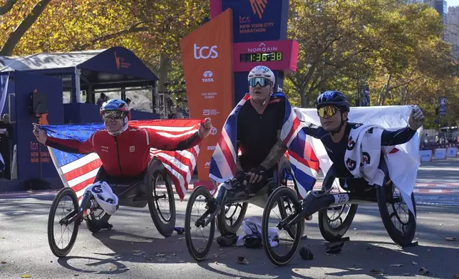 First place finisher Daniel Romanchuck, left, poses with second place finisher David Weir, of England, and Tomoki Zuzuki, of Japan, right, after winning the men's wheelchair division of the New York City Marathon, Sunday, Nov. 3, 2024, in New York. (AP Photo/Frank Franklin II)