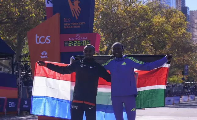 Women's division winner Sheila Chepkirui, right, poses with men's divsion winner Abdi Nageeye, of the Netherlands, during the New York City Marathon, Sunday, Nov. 3, 2024, in New York. (AP Photo/Frank Franklin II)