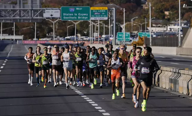 Yuma Morii, right, of Japan, makes his way onto the Verrazzano Narrows bridge with runners in the men's elite division make their way from the start line during the New York City Marathon, Sunday, Nov. 3, 2024, in New York. (AP Photo/Eduardo Munoz Alvarez)