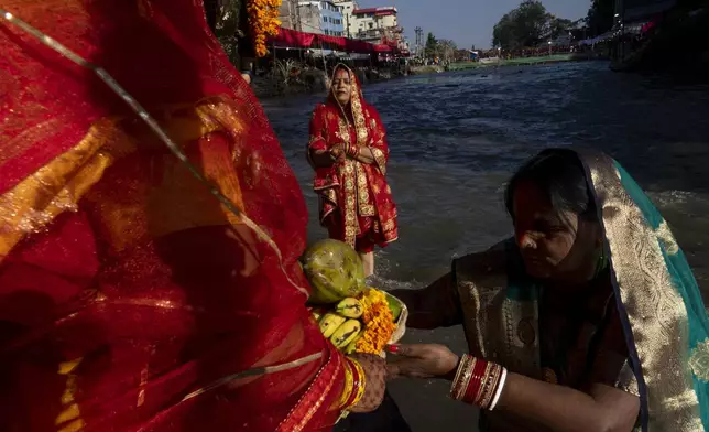 Nepalese women offer prayers to the setting sun on the bank of Bagmati River during the Chhath Puja festival in Kathmandu, Nepal, Thursday, Nov. 7, 2024. (AP Photo/Niranjan Shrestha)