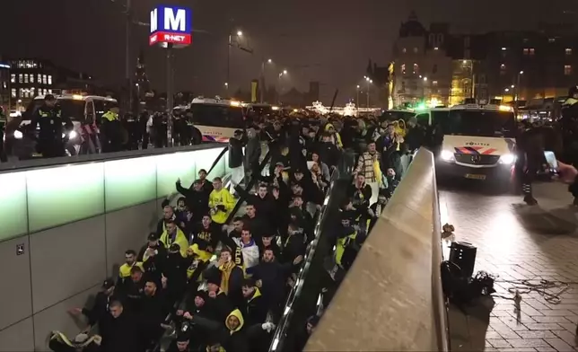 In this image taken from video, police escort Maccabi Tel Aviv supporters to the metro, after pro-Palestinian supporters marched near the soccer stadium, in Amsterdam, the Netherlands, Thursday, Nov. 7, 2024. (AP Photo InterVision)