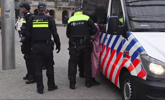 In this image taken from video, police detain a person next to the place where Maccabi Tel Aviv supporters gather ahead of the Europa League soccer match between their team and Ajax, in Amsterdam, the Netherlands, Thursday, Nov. 7, 2024. (AP Photo InterVision)