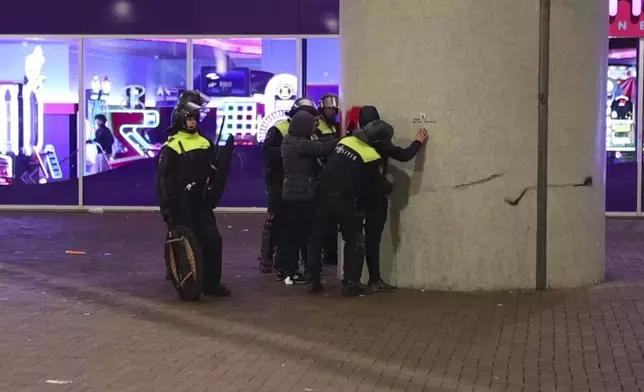 In this image taken from video, police frisk pro-Palestinian supporters near the Ajax stadium in Amsterdam, the Netherlands, Thursday, Nov. 7, 2024. (AP Photo InterVision)