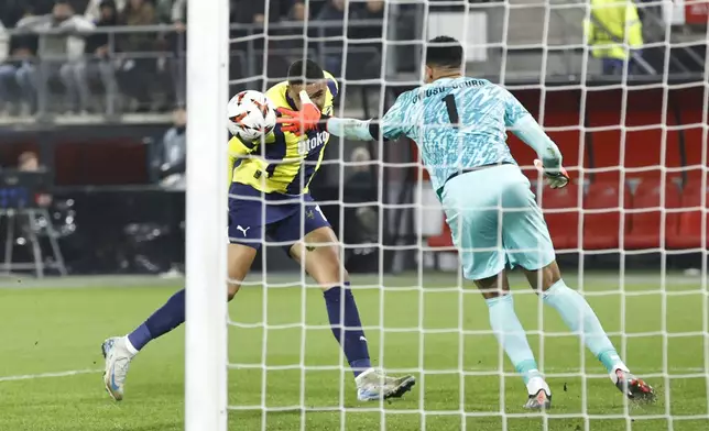 Fenerbahce's Youssef En-Nesyri scores his side's opening goal past AZ Alkmaar's goalkeeper Rome-Jayden Owusu-Oduro during the Europa League soccer match between AZ Alkmaar and Fenerbahce at the AFAS stadium, in Alkmaar, Netherlands, Thursday, Nov. 7, 2024. (AP Photo/Maurice van Steen)